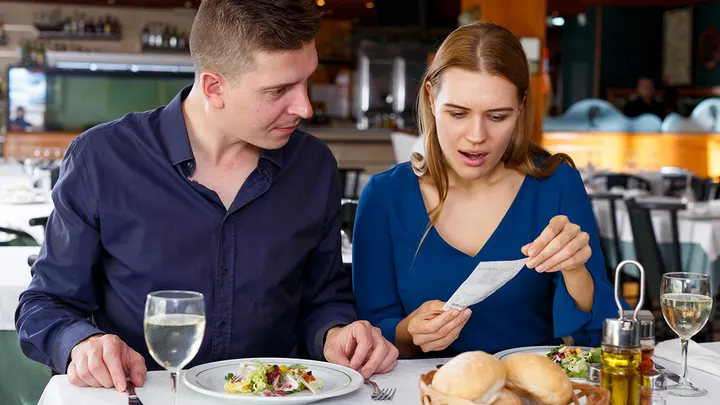 20266 03 28 couple looks at bill in restaurant
